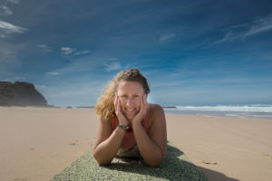 picture of Irina from YogaBusinessGrowth on a yoga mat on the beach