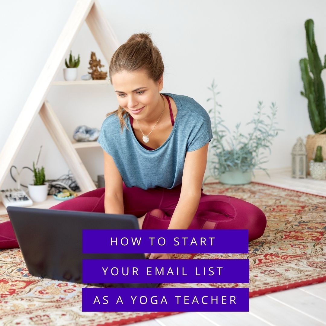 Yoga teacher sitting on a mat typing on a laptop